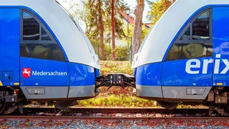 Zwei blau-graue Regionalzüge sind seitlich gekuppelt auf einem Gleis, mit sichtbarer Kupplung und Herbstbäumen im Hintergrund.